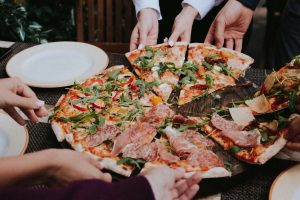 pizza being shared amongst friends